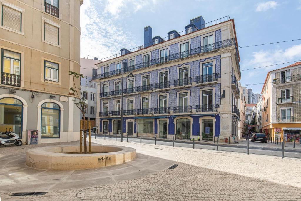 Ando Living - Abrantes Flats في لشبونة: شارع المدينة فيه مباني ونافورة في الوسط