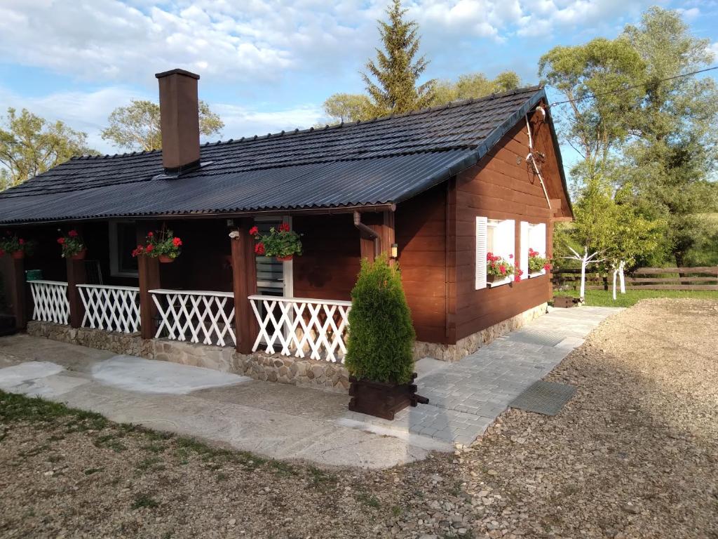 a small house with a black roof at Domek na Prerii in Ustrzyki Dolne