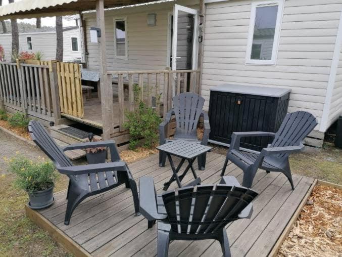 une terrasse avec des chaises, une table et un grill dans l'établissement Le balaou, à Lit-et-Mixe
