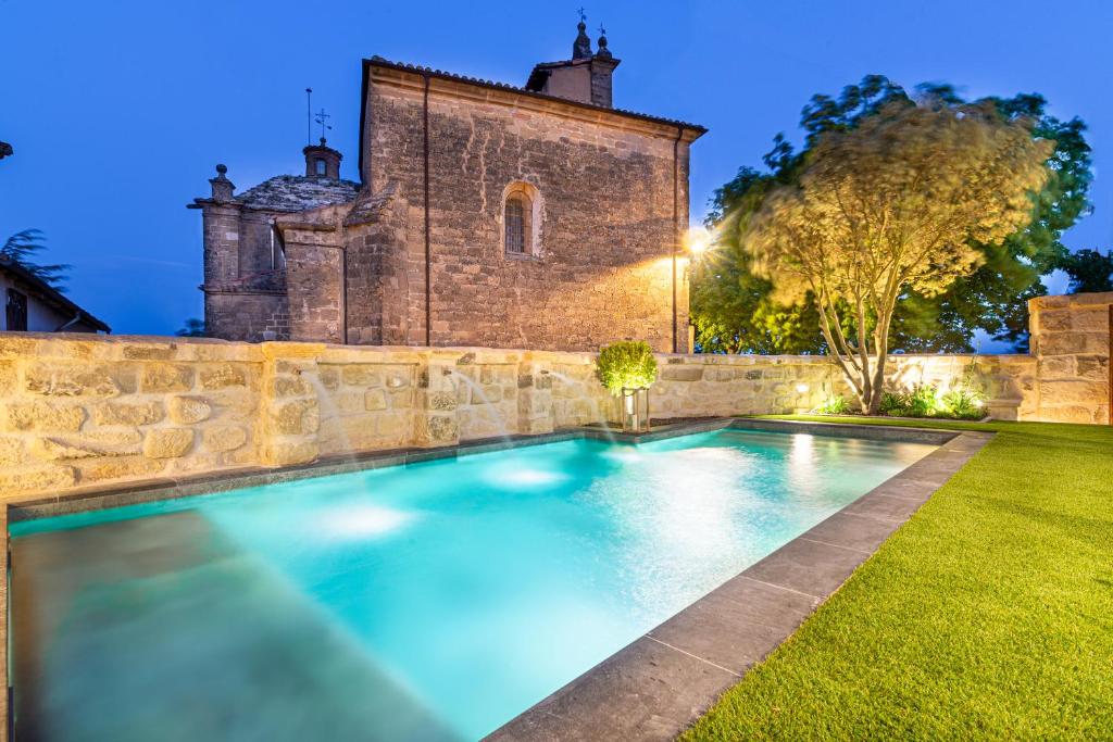 an outdoor swimming pool in front of a building at Palacio Condes de Cirac in Villalba de Rioja