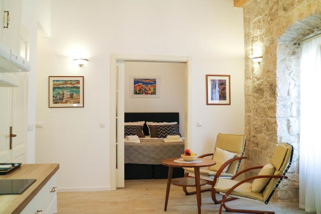 een keuken en een woonkamer met een tafel en een bed bij Sessa's Palace in Korčula