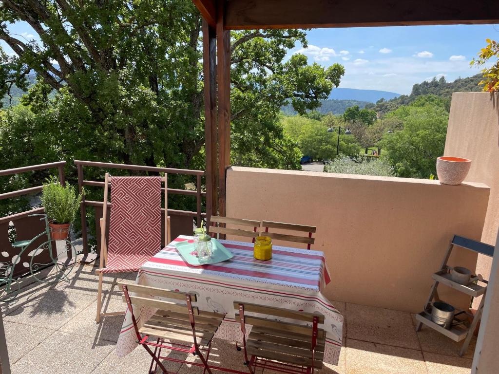 a table and chairs on a patio with a view at Superbe appartement au cœur du Luberon. in Goult