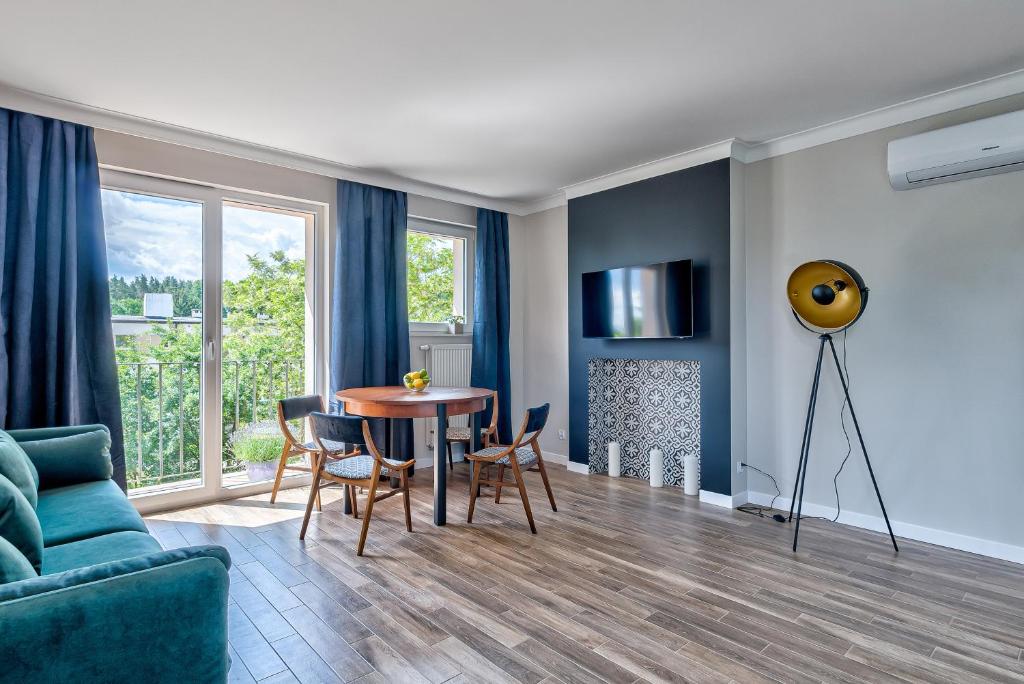 a blue living room with a table and chairs at Apartament Wschodni in Supraśl