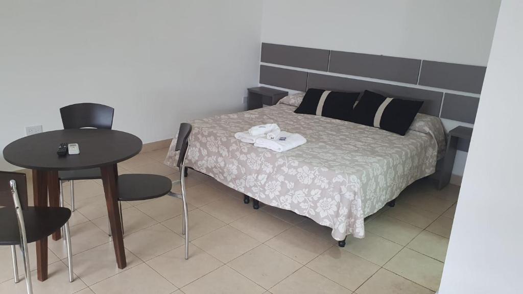a bedroom with a bed with a table and chairs at Urquiza in Salta