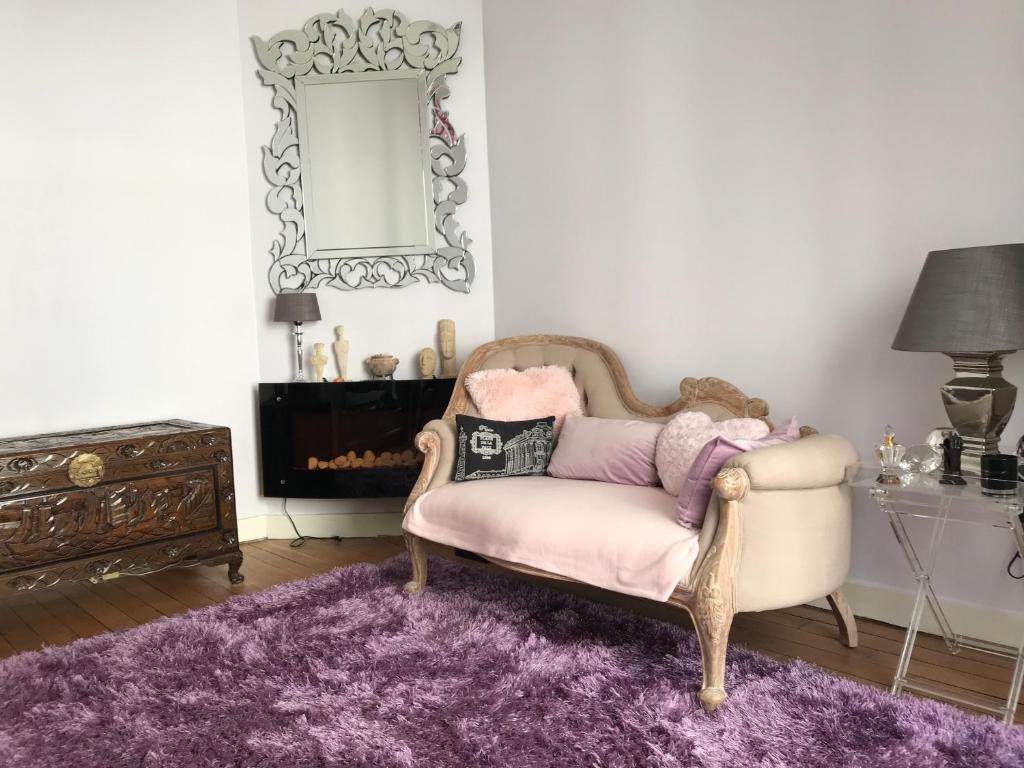 a living room with a chair and a mirror at Superbe appartement proche de la butte Montmartre in Paris