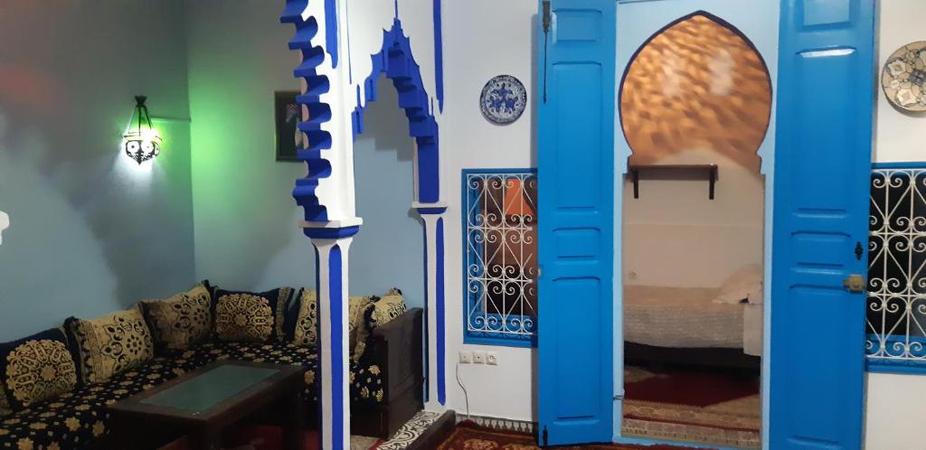 - un salon avec un canapé et un mur avec des assiettes dans l'établissement Riad Nerja, à Chefchaouen