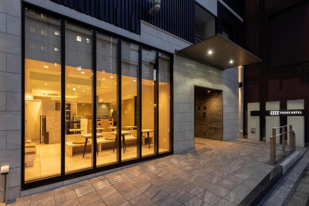 a building with large glass windows with a patio at Fourz Hotel Kintetsu Osaka-Namba in Osaka