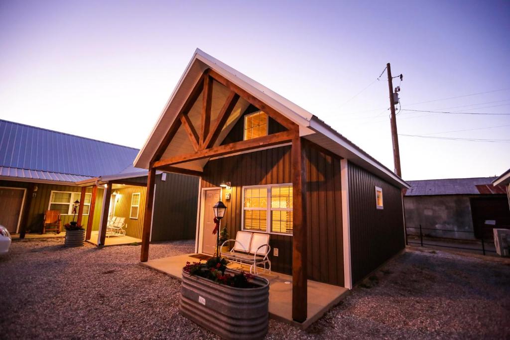 Cabaña pequeña con porche y silla en Knotty Squirrel Cabins en Mountain View