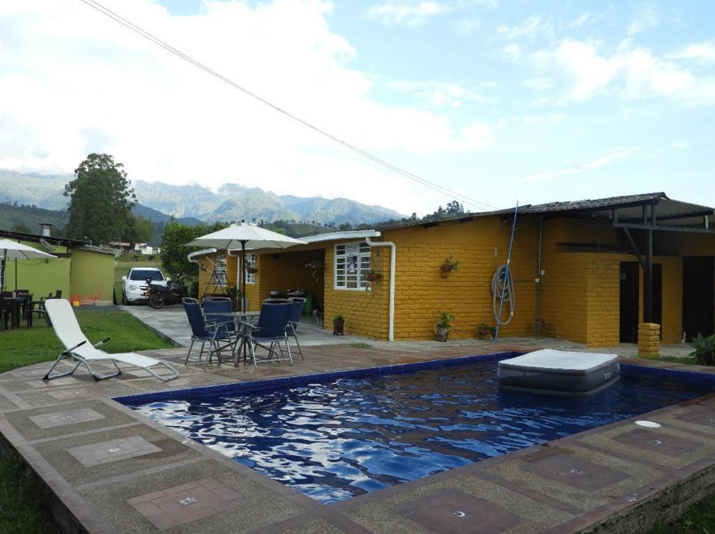 una casa con piscina frente a una casa en Hostal San Ramon, en Santa Rosa de Cabal