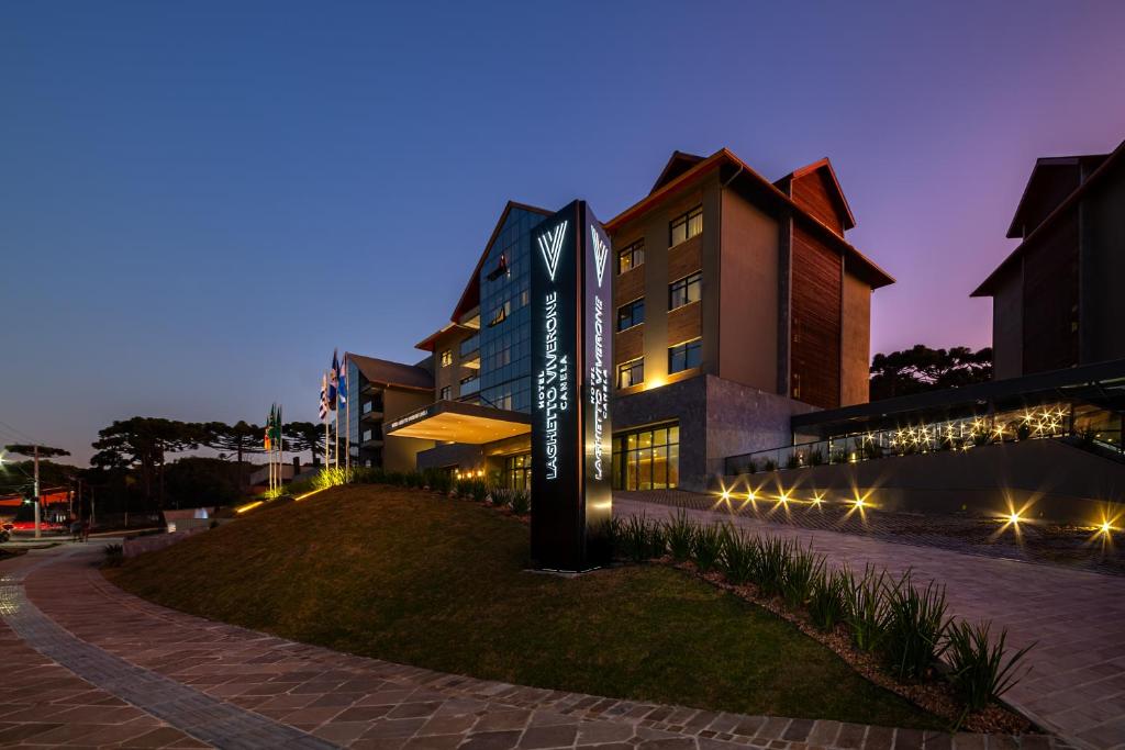 um edifício com uma placa à frente à noite em Laghetto Canela em Canela