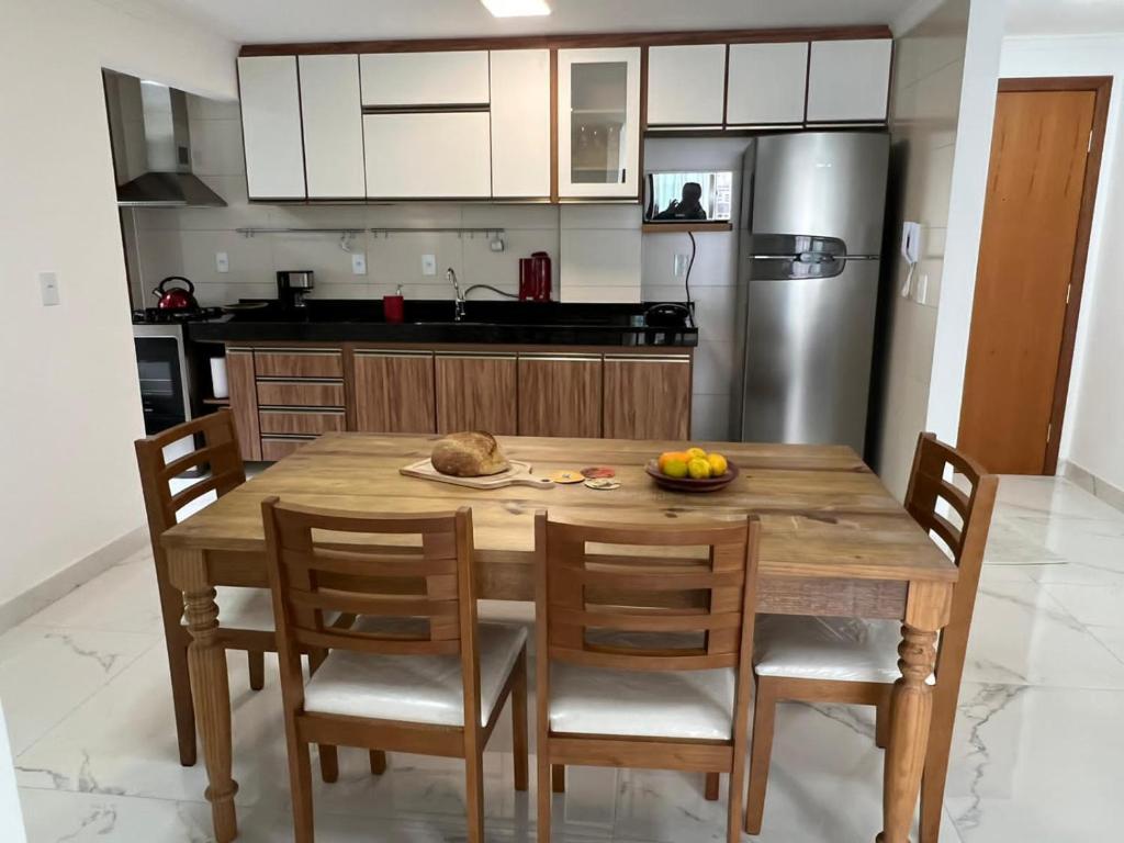 eine Küche mit einem Holztisch mit Stühlen und einem Kühlschrank in der Unterkunft Apartamento Encantador Centro Santa Teresa in Santa Teresa