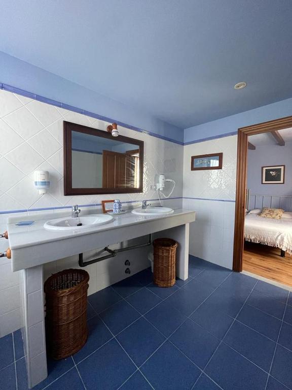 un baño con lavabo y espejo en Hotel Rural As Laguas, en Tapia de Casariego