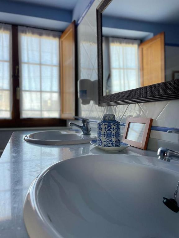Un baño con un lavabo blanco y un espejo. en Hotel Rural As Laguas, en Tapia de Casariego