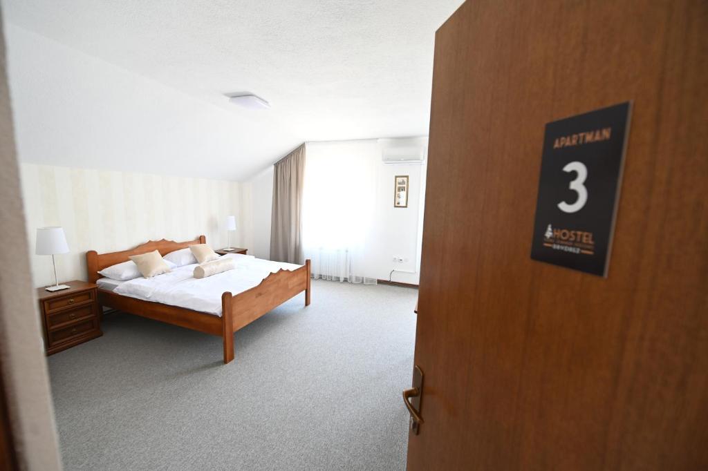 1 dormitorio con 1 cama y un cartel en la puerta en Hostel Sobe Drvorez, en Banja Luka