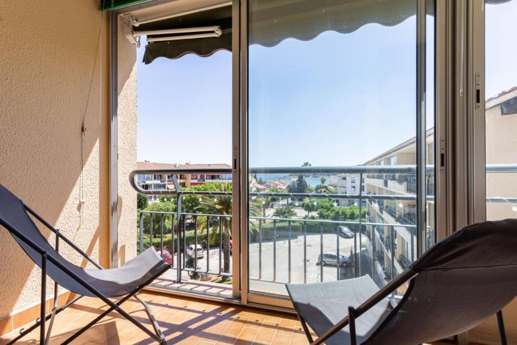 two chairs on a balcony with a view of a city at Cosy Apt Of 25 M Near The City View On Sea in La Seyne-sur-Mer