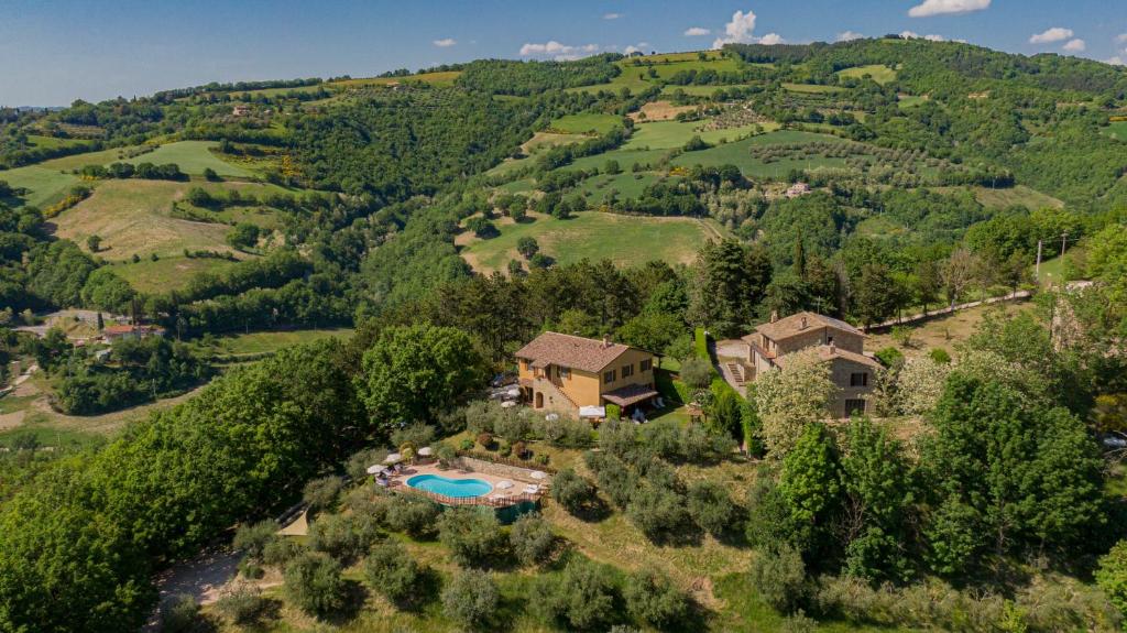 an estate in the hills with a swimming pool at Agriturismo Le Dolci Colline in Valfabbrica