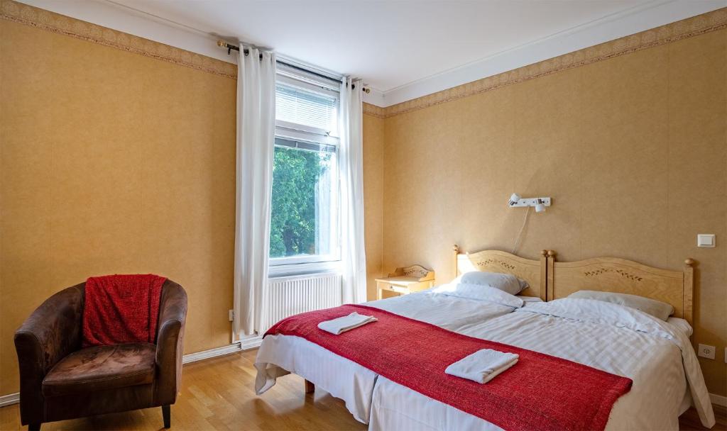 セーデルハムンにあるChristos Hotelのベッドルーム1室(ベッド1台、椅子、窓付)