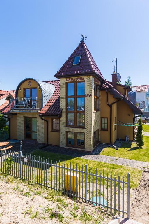 a house with a fence in front of it at Willa Mila in Trzęsacz