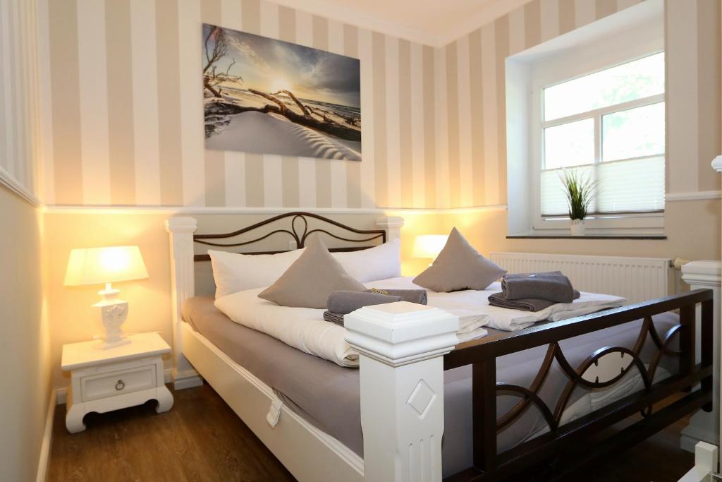 Schlafzimmer mit einem Bett mit weißer Bettwäsche und einem Fenster in der Unterkunft Ferienresidenz Fürst von Büttelkow in Rerik