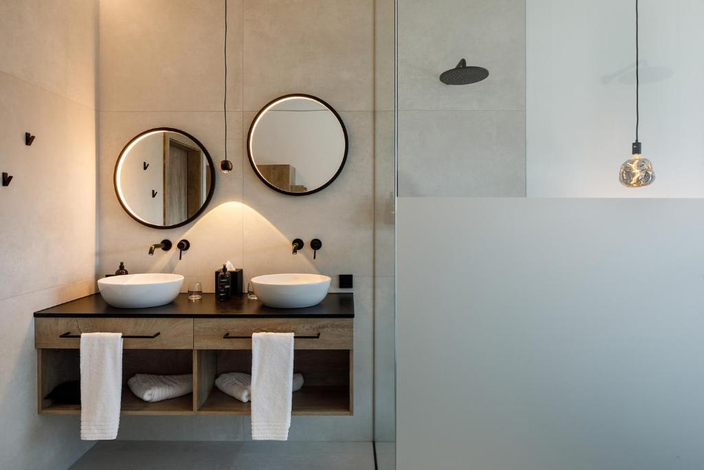 a bathroom with two sinks and two mirrors at The Hang Over in Andau