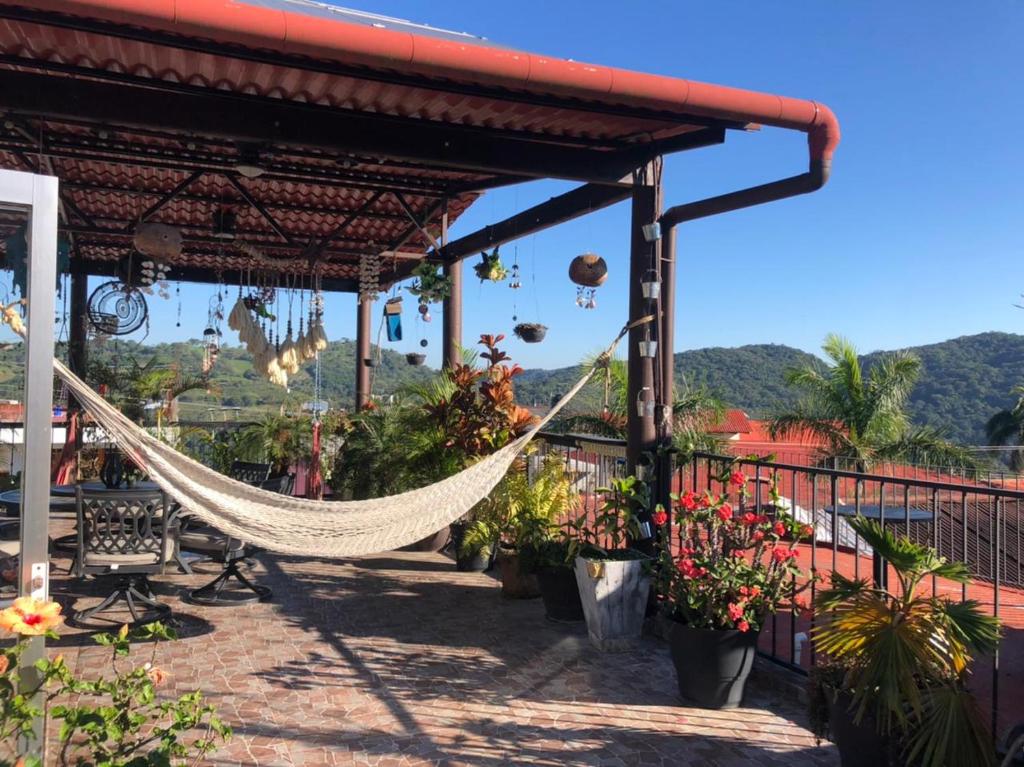 a hammock hanging from a building with flowers and plants at Grann Posada Xilitla in Xilitla