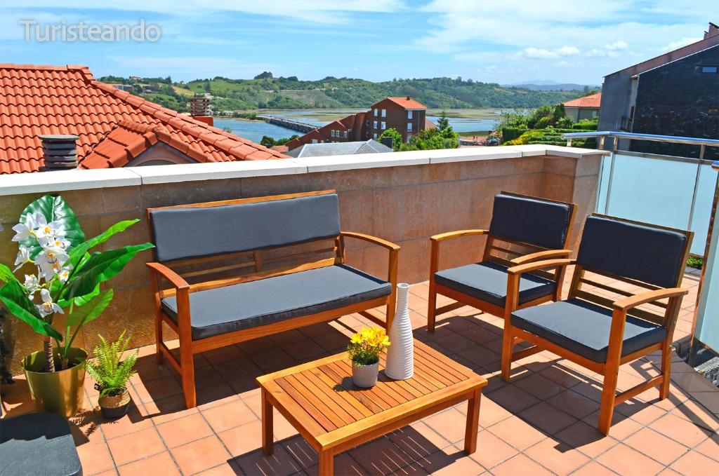 2 Stühle und ein Tisch auf dem Balkon in der Unterkunft Rincón del Cantábrico: para amantes de las buenas vistas in San Vicente de la Barquera