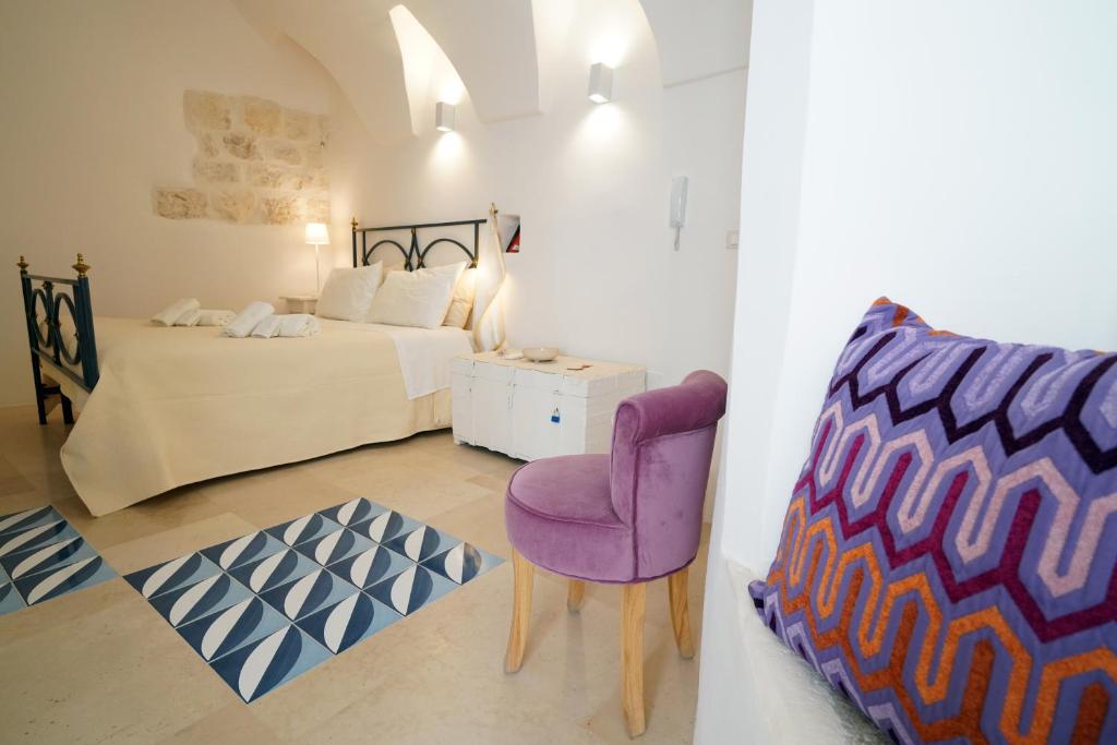 1 dormitorio con cama y silla morada en Blu_Cielo Terra, en Ostuni