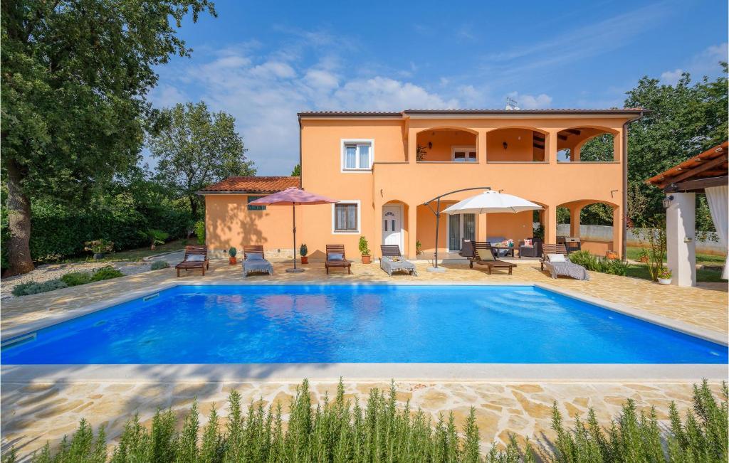 a villa with a swimming pool in front of a house at Lovely Home In Sv,lovrec With Kitchen in Stifanići