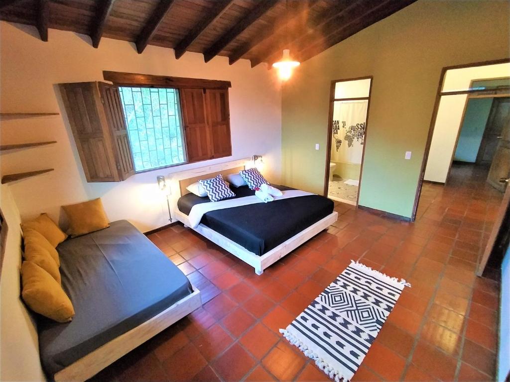 a bedroom with a bed and a couch at Finca Hostal Bolivar - Casa Quinta in Minca