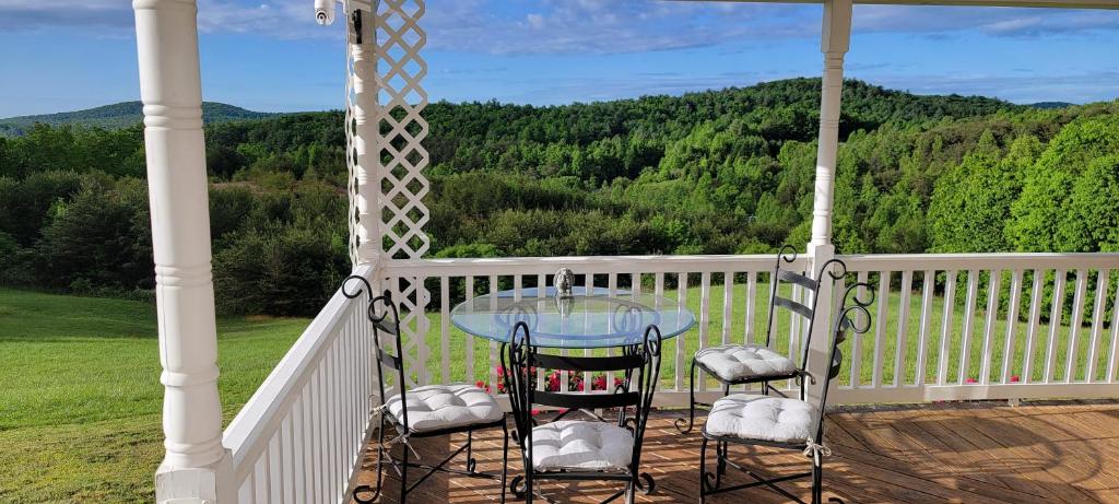 a porch with a glass table and two chairs at Mountain Retreat house to Relax and Enjoy in Lenoir