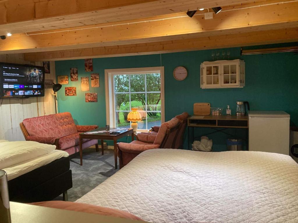 um quarto com uma cama e uma sala de estar em Rødseth Gårdsovernatting Familierom em Molde