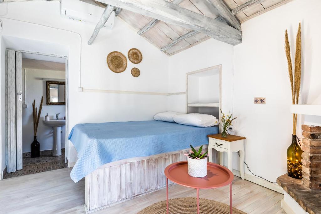 a bedroom with a bed and a table at Pefkias Tiny Cottage in Skopelos Town