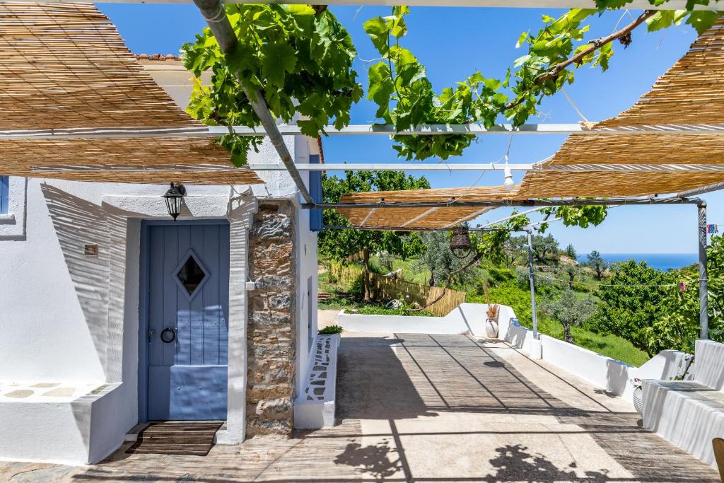 a house with a blue door and a view at Pefkias Tiny Cottage in Skopelos Town