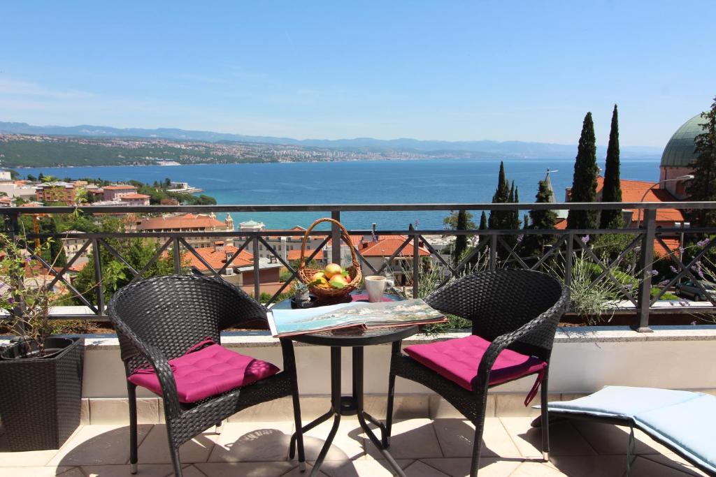 オパティヤにあるApartments Seccarecciaのテーブルと椅子、水辺の景色を望むバルコニー