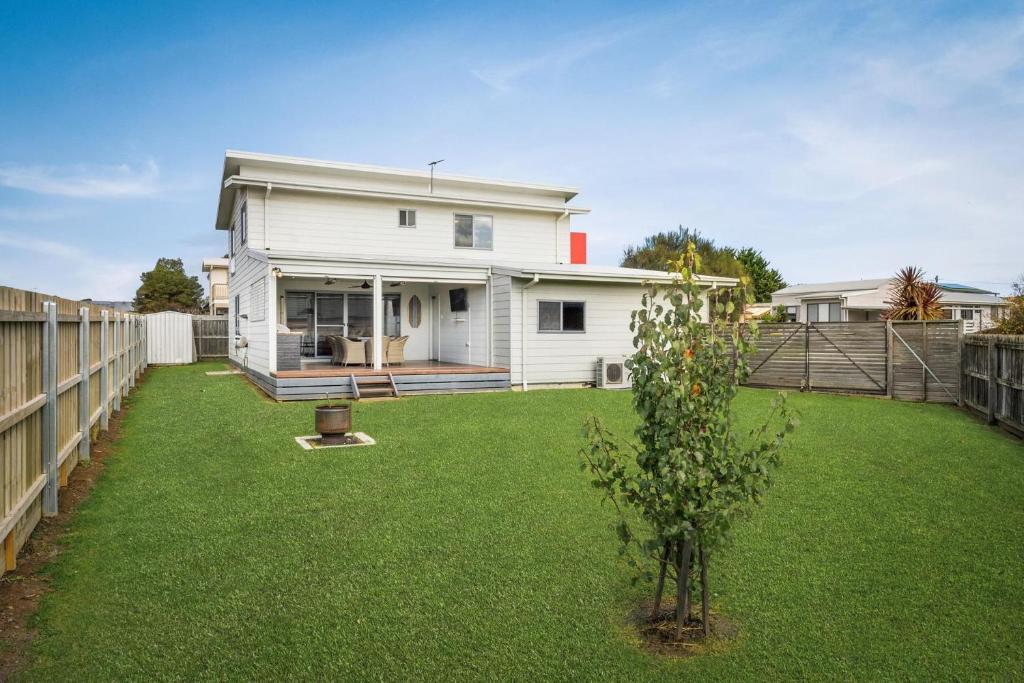 a white house with a yard with a fence at Casa Killara in Cowes