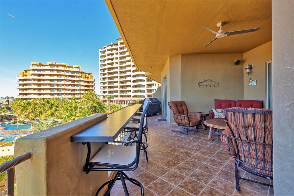 a bar on the balcony of a building with chairs at Bella Sirena 304-A - Elegant Oceanview Condo on Sandy Beach in Puerto Peñasco
