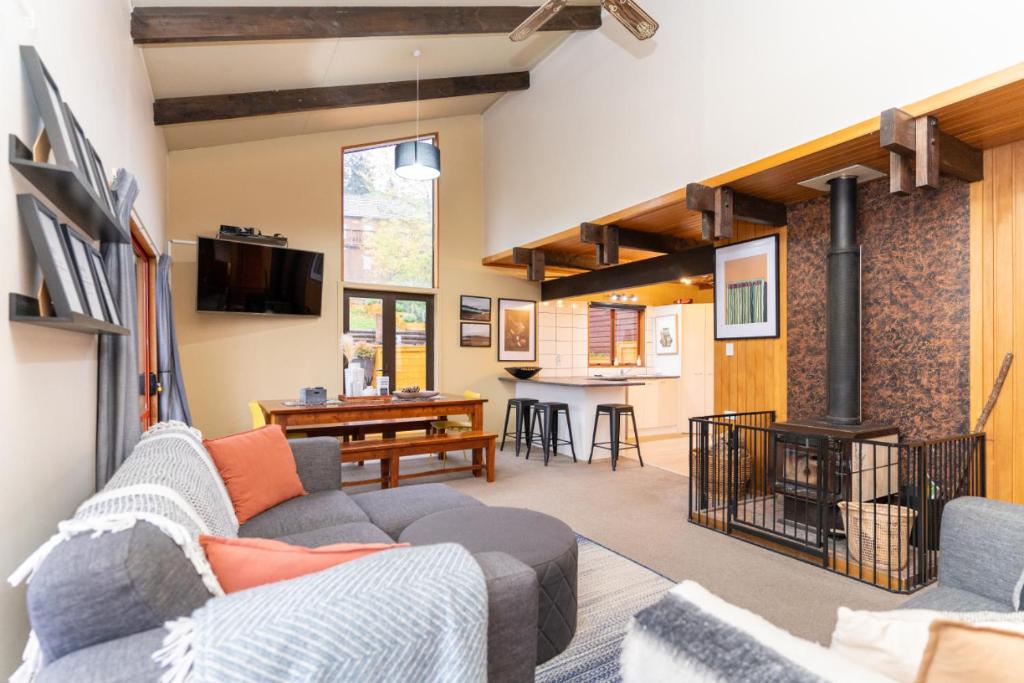 een woonkamer met een bank en een open haard bij 42a Alpine Avenue in Hanmer Springs