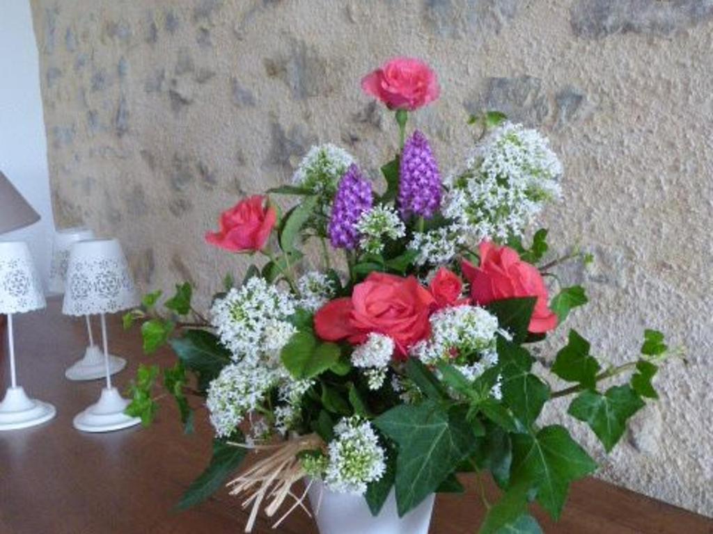 a white vase filled with flowers on a table at Gîte Le Bernard, 6 pièces, 10 personnes - FR-1-426-164 in Le Bernard