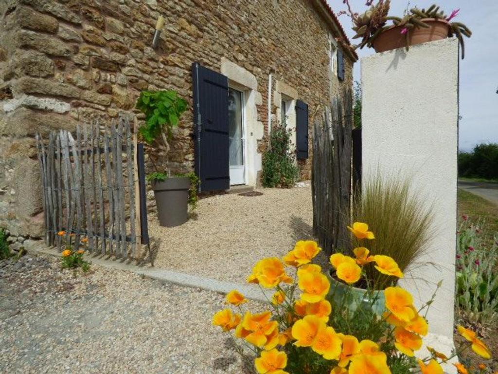 a brick building with a blue door and yellow flowers at Gîte Le Bernard, 6 pièces, 10 personnes - FR-1-426-164 in Le Bernard