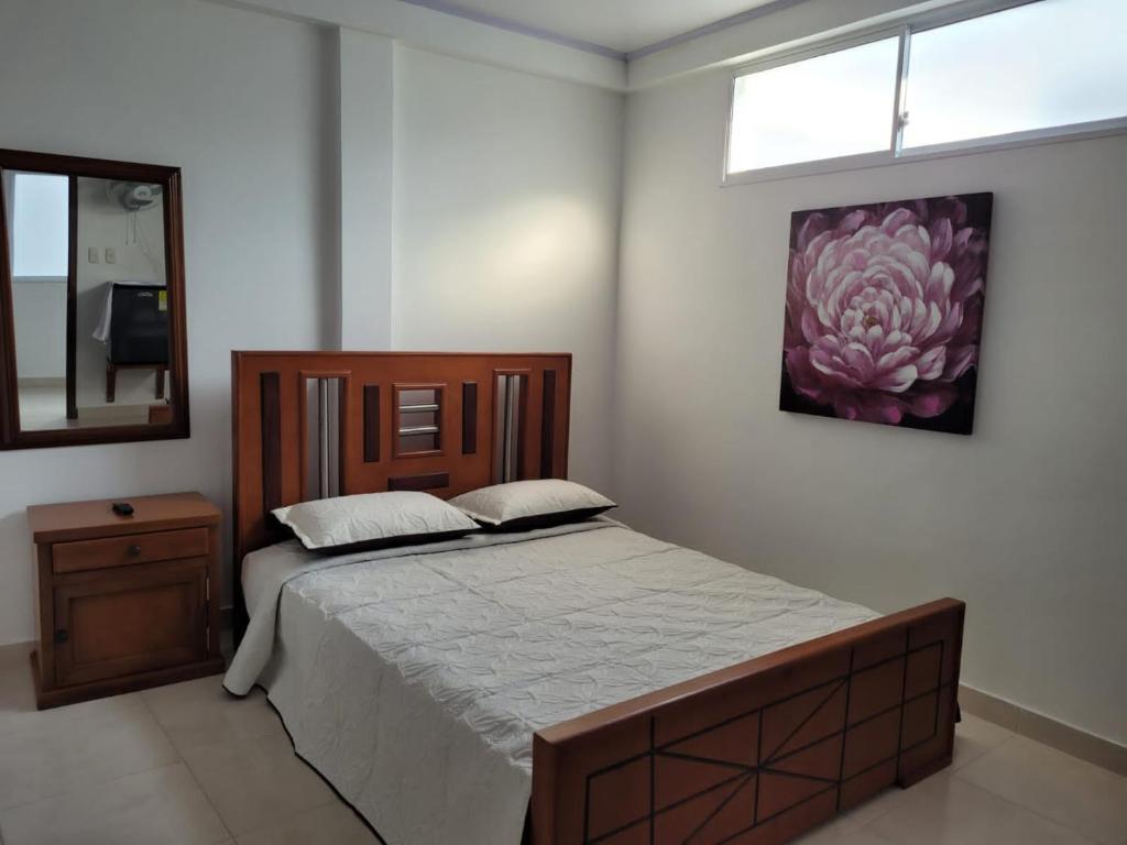 a bedroom with a bed and a painting on the wall at Edificio Tony - Alojamiento Aparta-Hotel in Barrancabermeja