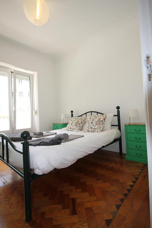 een slaapkamer met een groot bed en een houten vloer bij WELCOME TO LISBOA in Lissabon