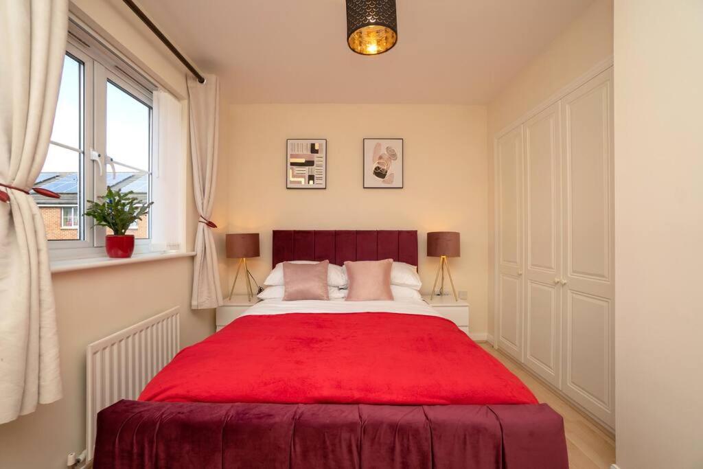 a bedroom with a red bed with a red blanket at Bristol's Coach House - 2 Bedroom Detached Apartment with Secure Parking in Bristol