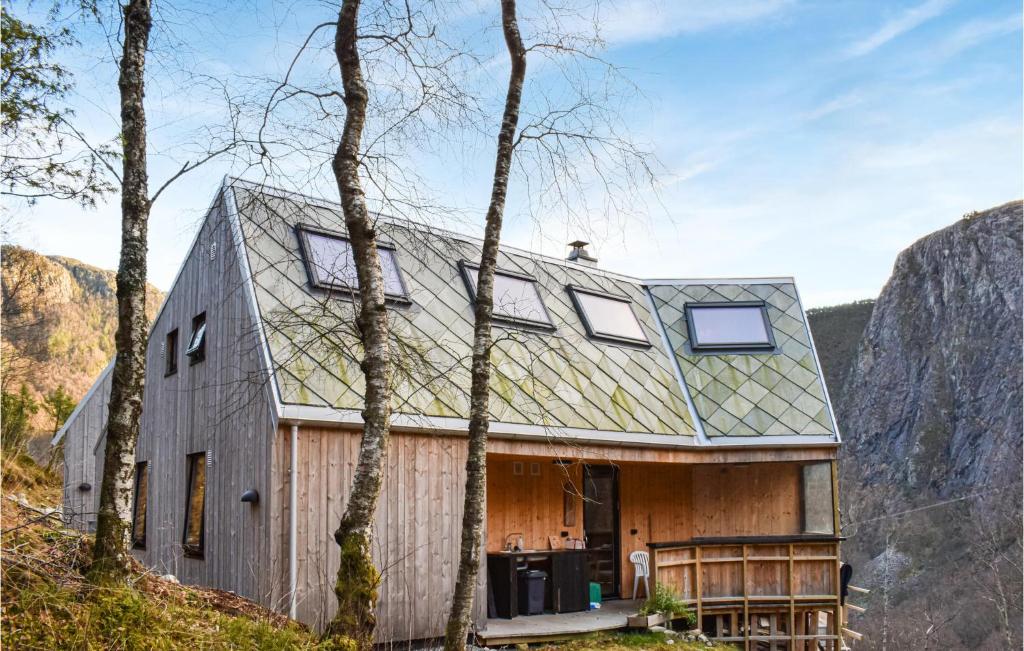 Stunning Home In Erfjord With Wifi في Erfjord: منزل في الجبال بسقف معدني