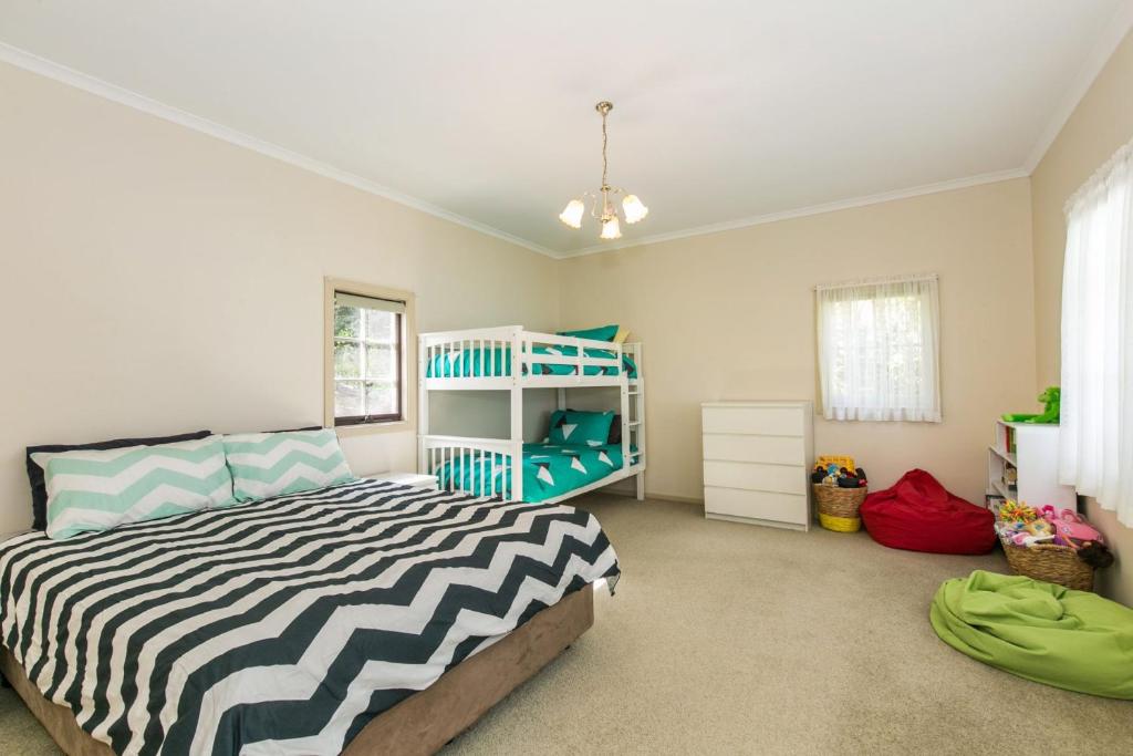 una camera da letto con un letto a righe di Grand Vue a Lorne