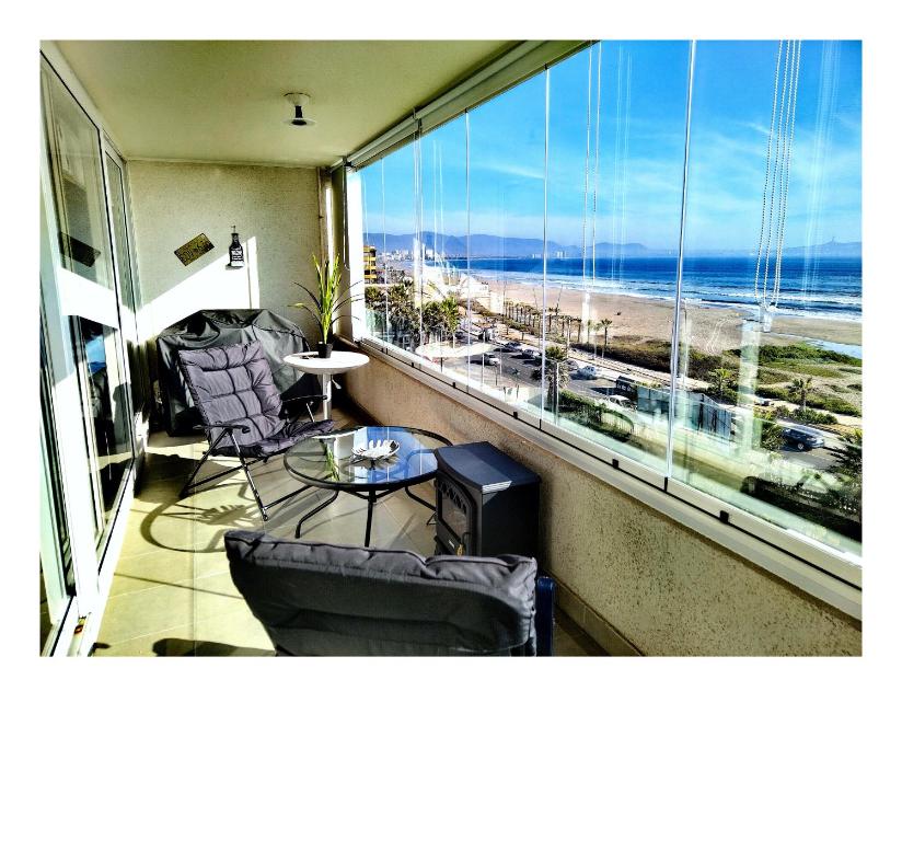 a room with a balcony with a view of the beach at Departamento primera linea vista privilegiada La Serena in La Serena