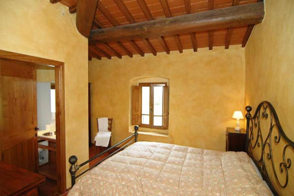 1 dormitorio con 1 cama grande en una habitación en Il Bellini - Tuscany farmholiday, en Pulicciano