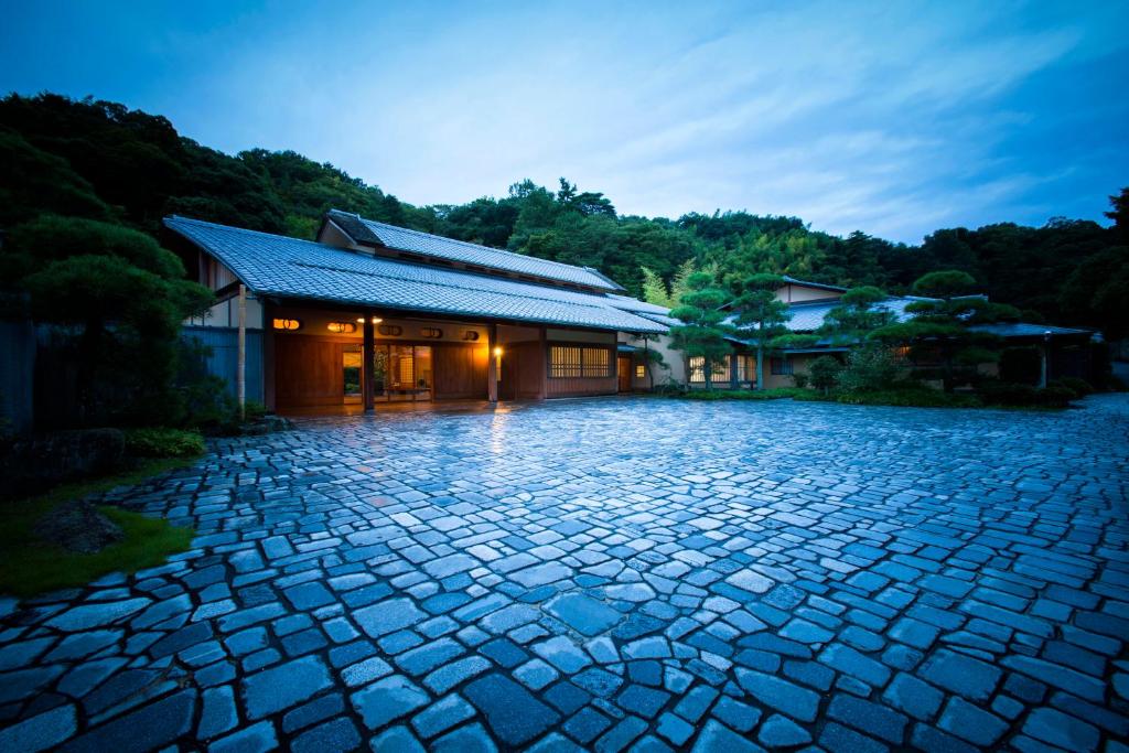 a stone driveway in front of a building at Sanyo-so in Izunokuni