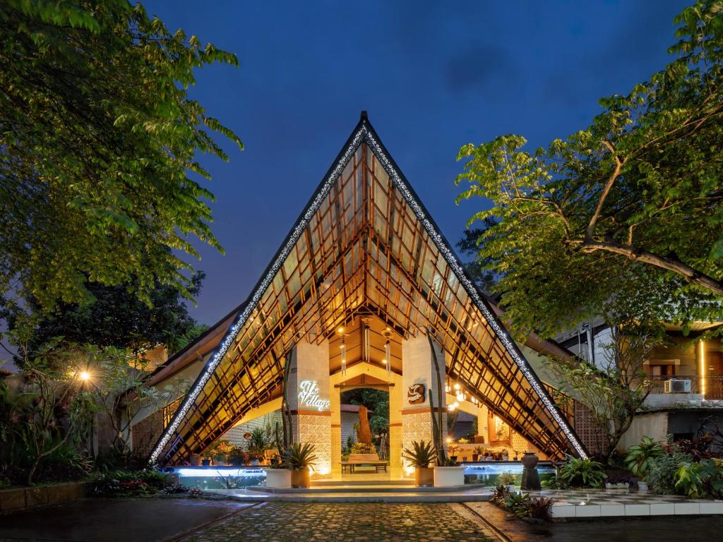 un edificio con una fachada de pirámide por la noche en The Village Resort Bogor By Waringin Hospitality, en Bogor