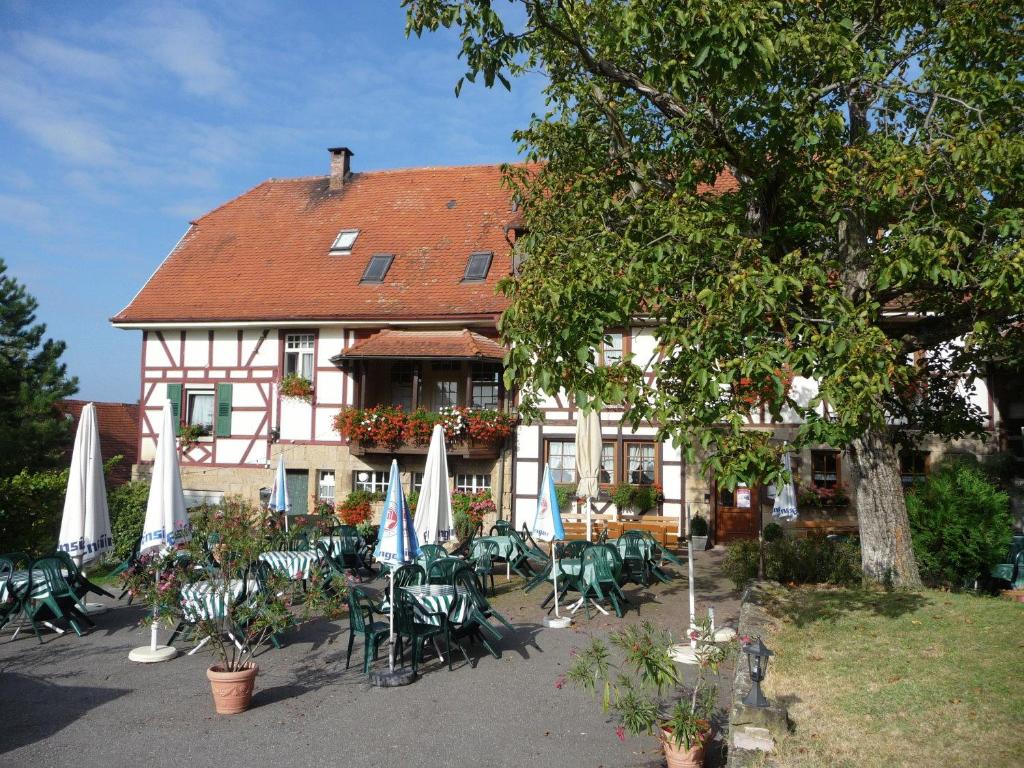 um edifício com mesas e cadeiras em frente em Wengerterstube & Gästezimmer Kern em Oberderdingen