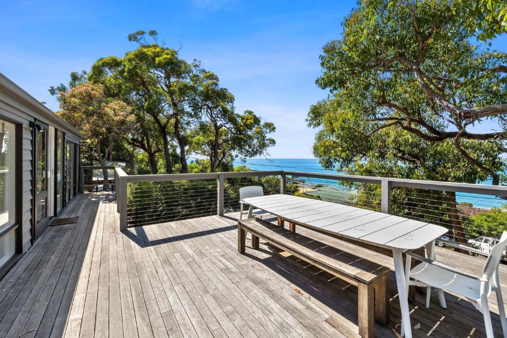 洛恩的住宿－Retro Beach Vibes，木甲板上设有野餐桌和海洋